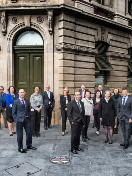 corporate photography. Group of executives in front of a classic city building