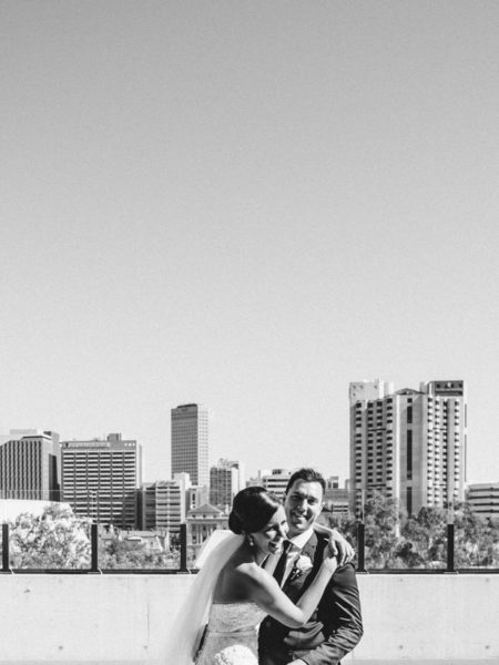 couple laughing and embracing with adelaide skyline wedding photography prices